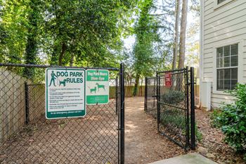 A sign for Dog Park Rules is posted on a fence.